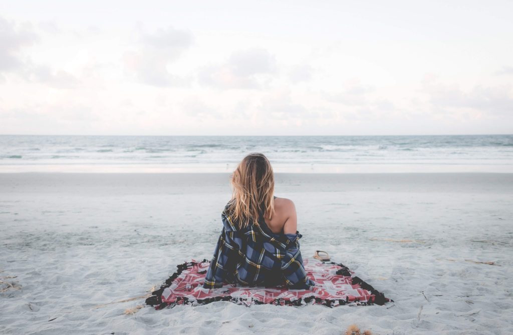 woman in a beach looking at waves