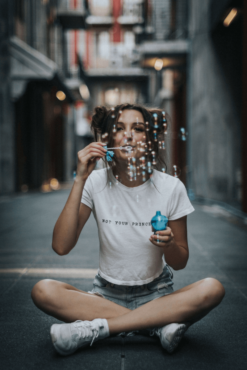 girl cross legged blowing bubbles
