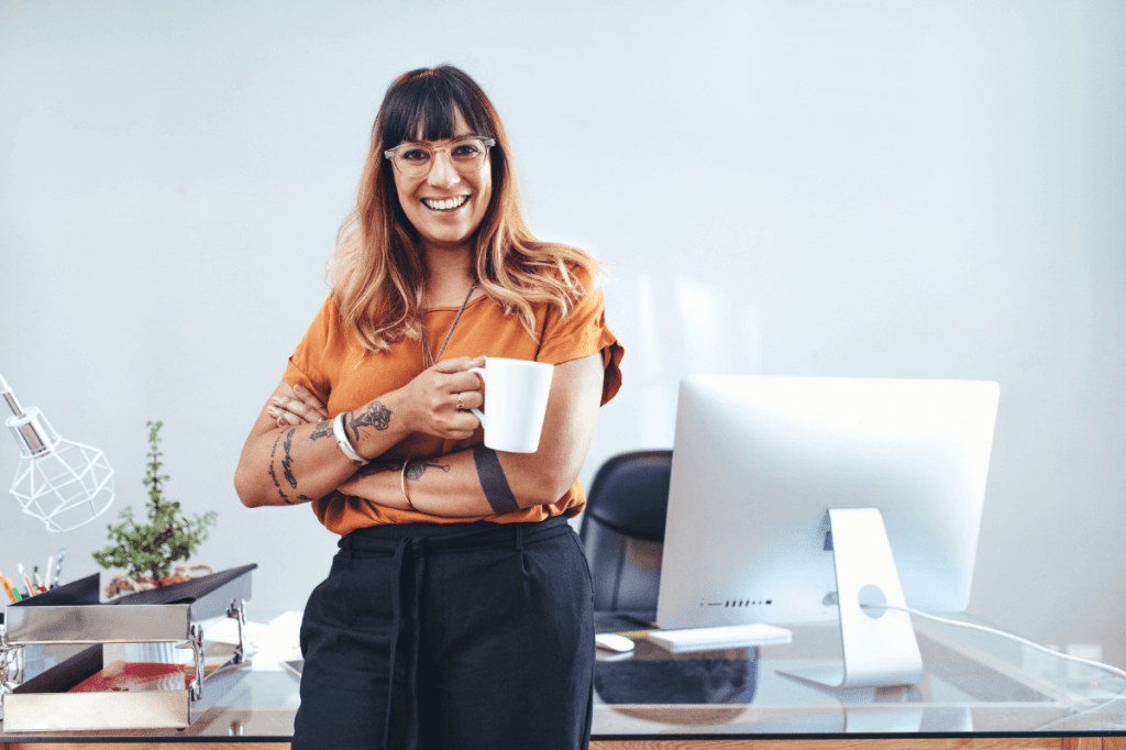 woman with cup of coffee in front of a computer